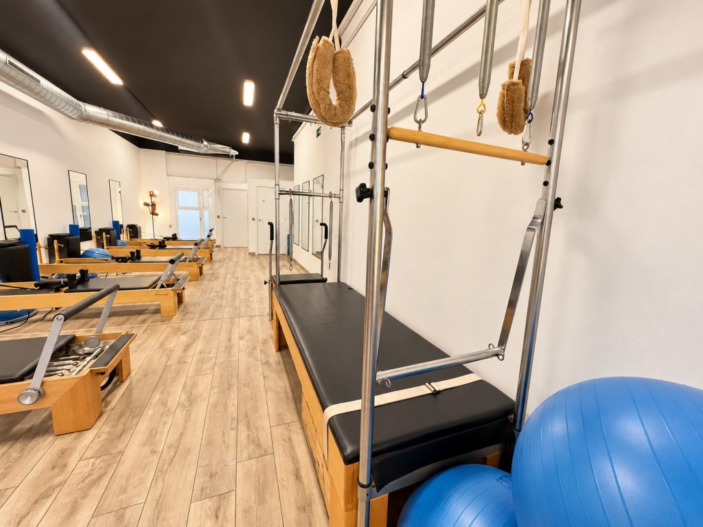 Máquina Cadillac junto a la fila de Reformers en el centro Alegría de Pilates Esplugues