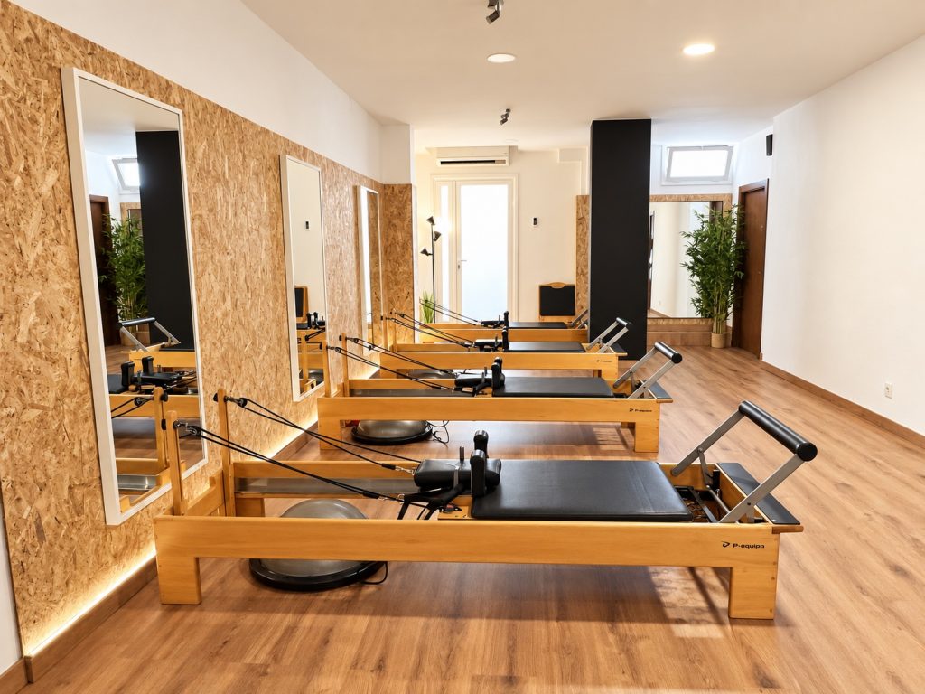 Fila de máquinas Reformer con espejos en el centro Campreciós de Pilates Esplugues