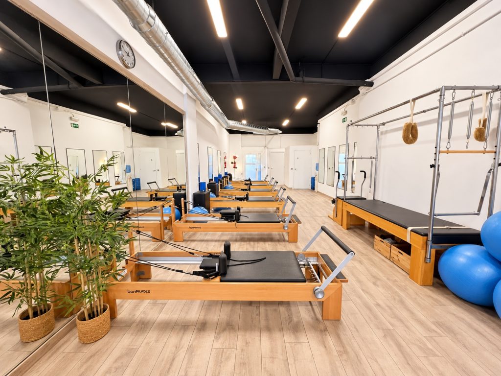 Estudio con máquinas Reformer y espejos en el centro Alegría de Pilates Esplugues